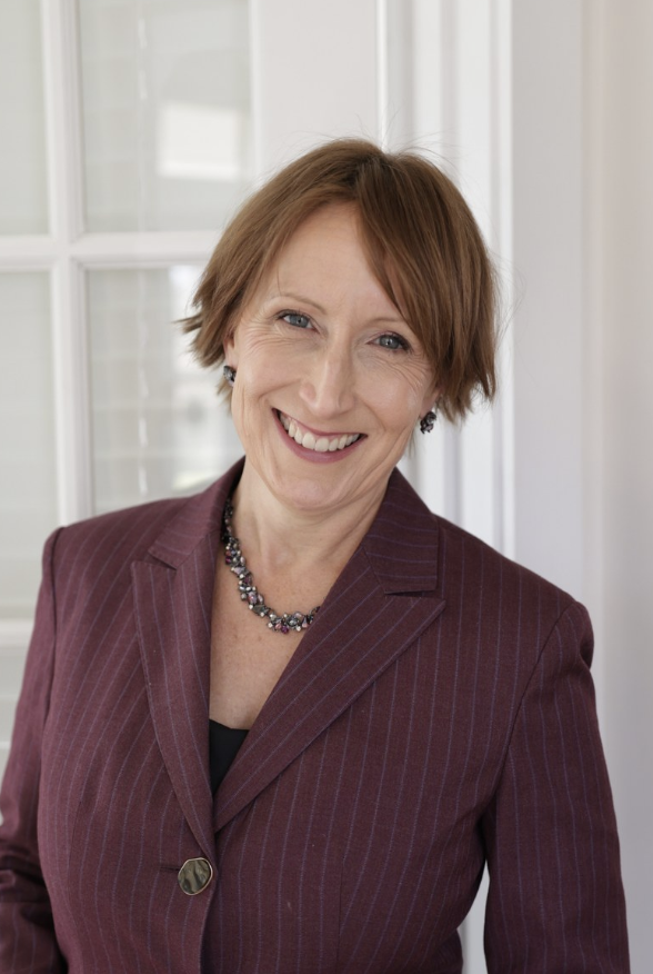 Emi Kirschner smiling in a burgundy jacket